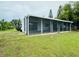 A screen enclosed porch is attached to the rear of this home at 3516 Norland Ct, Holiday, FL 34691