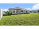 The backyard has green grass, a patio, and large windows at 10211 Cakebread Ln, Riverview, FL 33578