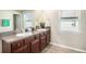 Bathroom with dual sinks, wood cabinets and granite countertops at 10211 Cakebread Ln, Riverview, FL 33578