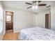 Bright bedroom features wood floors, a ceiling fan, and an ensuite bathroom at 10211 Cakebread Ln, Riverview, FL 33578