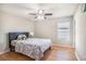 Bedroom with hardwood floors, bed, ceiling fan and a large window at 10211 Cakebread Ln, Riverview, FL 33578