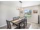 Formal dining room features modern lighting, a large window offering natural light, and seating for six at 10211 Cakebread Ln, Riverview, FL 33578