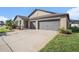 A bright two-car garage adds convenince to this one-story home, accented by a lovely, landscaped lawn at 10211 Cakebread Ln, Riverview, FL 33578