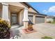 Inviting front exterior featuring a well-maintained lawn, a convenient two-car garage, and a welcoming front door at 10211 Cakebread Ln, Riverview, FL 33578