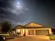 Exterior front view of single-story home at night showcasing the well-kept lawn, two-car garage, and cozy entrance at 10211 Cakebread Ln, Riverview, FL 33578