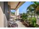 Cozy front porch with seating area surrounded by lush landscaping, complemented by views of the neighborhood at 10211 Cakebread Ln, Riverview, FL 33578