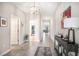 Bright and open hallway featuring tiled flooring, decorative lighting, and access to multiple rooms in the house at 10211 Cakebread Ln, Riverview, FL 33578