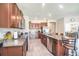 Eat-in kitchen boasts stainless appliances, granite counters, tile flooring, and wood cabinetry at 10211 Cakebread Ln, Riverview, FL 33578