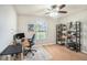 Bright office with hardwood floors, ceiling fan, desk, shelving and large window at 10211 Cakebread Ln, Riverview, FL 33578