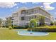 Charming view of a lovely condominium featuring lush landscaping, fountain, grass, trees, and walkway at 1060 N Shore Ne Dr # 6, St Petersburg, FL 33701