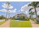 Inviting exterior view of a condominium featuring lush landscaping, grass, trees, and walkway at 1060 N Shore Ne Dr # 6, St Petersburg, FL 33701