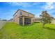 Backyard with a manicured green lawn, privacy fence, and screened-in lanai at 11464 Chilly Water Ct, Riverview, FL 33569