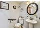 Cozy bathroom showing toilet, sink, decorative artwork, and natural lighting at 12413 Dawn Vista Dr, Riverview, FL 33578