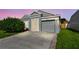 Well-maintained home with a gray facade, two-car garage, and a neatly paved driveway at 12413 Dawn Vista Dr, Riverview, FL 33578