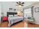 Comfortable bedroom features a ceiling fan, wood floors, and a window for natural light at 12413 Dawn Vista Dr, Riverview, FL 33578