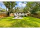 Spacious backyard featuring a cozy fire pit seating area, lush lawn and privacy fence, perfect for outdoor activities at 1275 Palm St, Clearwater, FL 33755