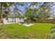Expansive backyard featuring mature trees, lush lawn, and outdoor seating area, perfect for entertaining and relaxation at 1275 Palm St, Clearwater, FL 33755