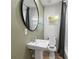 A modern bathroom features a pedestal sink, oval mirror, and shower with gray curtain at 1435 Prescott S St, St Petersburg, FL 33712