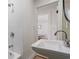 A modern sink and shower with white tile, and view into a bright dining room at 1435 Prescott S St, St Petersburg, FL 33712