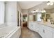 This bathroom offers a soaking tub and double vanity with stone countertops at 15217 Octavia Ln, Odessa, FL 33556