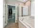 The luxurious bathroom showcases a glass shower and a separate soaking tub at 15217 Octavia Ln, Odessa, FL 33556