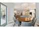 Bright dining area with stylish light fixture sits adjacent to open kitchen and living room at 15217 Octavia Ln, Odessa, FL 33556