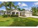 Inviting home featuring a well-manicured lawn, lush landscaping, and a three-car garage at 15217 Octavia Ln, Odessa, FL 33556