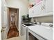Practical laundry room featuring modern appliances, cabinetry, and stylish flooring at 15217 Octavia Ln, Odessa, FL 33556