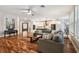 Open concept living room features hardwood floors, large windows, and access to the kitchen at 15217 Octavia Ln, Odessa, FL 33556