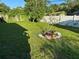 Fenced backyard featuring a landscaped area with a small tree, potted plants, and stones at 1605 Logan St, Clearwater, FL 33755