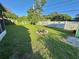 Fenced backyard featuring a landscaped area with a small tree, potted plants, and stones at 1605 Logan St, Clearwater, FL 33755