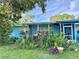 Landscaped yard showcases the exterior of this single story home with screened in porch at 1605 Logan St, Clearwater, FL 33755