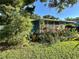 Landscaped yard showcases the exterior of this single story home with screened in porch at 1605 Logan St, Clearwater, FL 33755