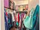 Organized walk-in closet with clothes hanging on racks and luggage stored on shelving above at 1605 Logan St, Clearwater, FL 33755