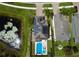 Top-down view of a home with solar panels, a pool, and proximity to a pond, beautifully landscaped at 19636 Long Lake Ranch Blvd, Lutz, FL 33558