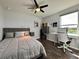 Well-lit bedroom with a gray accent wall, hardwood floors, and a scenic view at 19636 Long Lake Ranch Blvd, Lutz, FL 33558