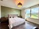 Bright bedroom featuring a decorative accent wall, modern lighting, hardwood floors, and a scenic view at 19636 Long Lake Ranch Blvd, Lutz, FL 33558
