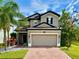 Beautiful two-story home featuring a brick driveway, tropical landscaping, and a two-car garage at 19636 Long Lake Ranch Blvd, Lutz, FL 33558