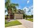 Charming two-story home featuring a brick driveway, tropical landscaping, and a two-car garage at 19636 Long Lake Ranch Blvd, Lutz, FL 33558