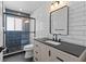 Modern bathroom features tiled shower with glass door and a vanity with a black countertop at 2 79Th S St, St Petersburg, FL 33707