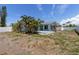 Light blue home with palms, a white fence and a well-kept lawn at 2 79Th S St, St Petersburg, FL 33707