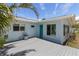 Light blue home featuring a gray patio deck and a turquoise front door at 2 79Th S St, St Petersburg, FL 33707