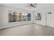 Bright living room features light wood-look floors, large windows, and a ceiling fan at 2 79Th S St, St Petersburg, FL 33707