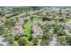 An aerial view shows properties with beautiful landscaping and mature trees surrounding a scenic pond at 20302 Noble Oak Pl, Tampa, FL 33647