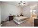 Neutral bedroom with king bed, side tables, ceiling fan and attached bathroom at 20302 Noble Oak Pl, Tampa, FL 33647