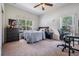 Inviting bedroom with warm carpet flooring, large windows, and a functional workspace for productivity at 20302 Noble Oak Pl, Tampa, FL 33647