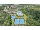Aerial view showcasing the community pool, tennis courts and clubhouse surrounded by lush landscaping and mature trees at 20302 Noble Oak Pl, Tampa, FL 33647