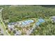 Aerial view of the community pool with a playground, tennis courts and a clubhouse surrounded by mature trees at 20302 Noble Oak Pl, Tampa, FL 33647
