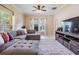 Open living room with large windows, a gray sectional, and a stylish entertainment center at 20302 Noble Oak Pl, Tampa, FL 33647