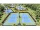 Aerial view of tennis courts with blue and green playing surfaces and tropical landscape at 20302 Noble Oak Pl, Tampa, FL 33647